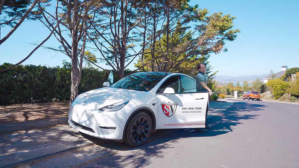 SoundVision project manager arriving on-site in the Tesla Model Y work vehicle