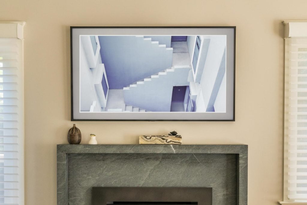 65" Custom Frame TV displaying artwork above the fireplace
