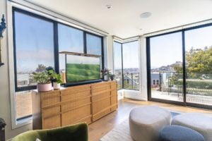 Wide shot of living room with a 49" Samsung 4K TV on a Nexus L-50 Motorized Lift to raise the TV out of a custom cabinet with a Sonos Arc sound bar