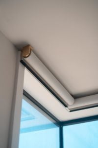 Lutron Palladiom shades in the corner of a room with brushed gold brackets