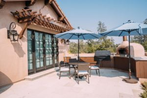 Outdoor kitchen and seating area with two outdoor Sonance Mariner 66 speakers